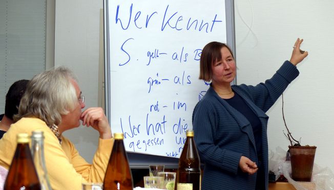 Monika Peukert erklärt den Mitgliedern des Arbeitskreises Streuobst die zahlreichen Verwendungsmöglichkeiten der Speierlings-Früchte.